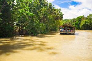 barco de crucero exótico con turistas en un río de la selva loboc, bohol foto
