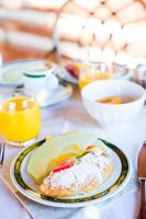 desayuno saludable con jugo fresco y croissant dulce en el restaurante al aire libre foto