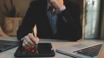 groupe d'hommes d'affaires utilisant une tablette numérique ensemble devant les fenêtres d'un immeuble de bureaux donnant sur la ville video