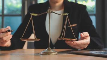 Business and lawyers discussing contract papers with brass scale on desk in office. Law, legal services, advice, justice and law concept picture with film grain effect video