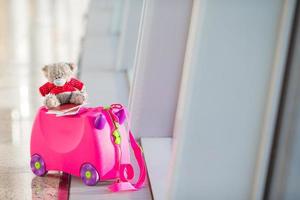 Closeup small kids luggage in airport near window photo