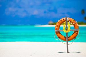 Lifebuoy on tropical white beach photo