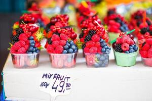 Berries fruits at a marketplace. Blueberries, raspberries, strawberries, cherries and blackberries on the market. photo