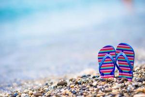 Kids flip flop on beach in front of the sea photo