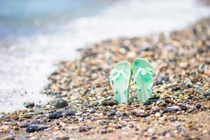 Kids flip flop on beach in front of the sea photo