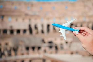 Closeup toy airplane on Colosseum background. Italian european vacation in Rome. Concept of imagination. photo