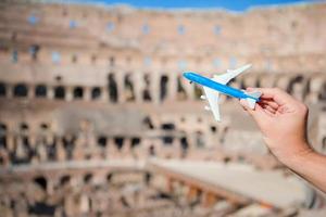 Closeup toy airplane inside on Colosseum background. Italian european vacation in Rome. Concept of travel imagination. photo