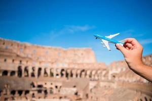 Closeup toy airplane on Colosseum background. Italian european vacation in Rome. Concept of imagination. photo