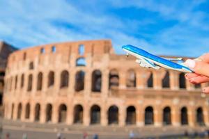 Closeup toy airplane on Colosseum background. Italian european vacation in Rome. Concept of imagination. photo