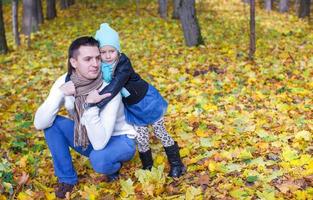 Cute little daughter with young daddy enjoy their autumn vacation on a sunny day photo