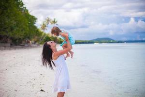 la joven madre y su linda hija se divierten en una playa exótica foto