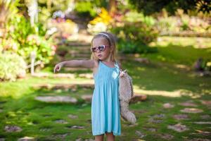 Little girl walking in tropical green hotel photo