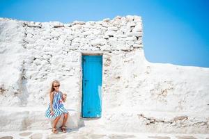 Adorable little girl at old street of typical greek traditional village photo