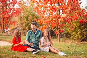 Family of dad and kids on beautiful autumn day in the park photo