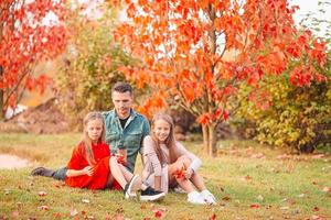 Family of dad and kids on beautiful autumn day in the park photo