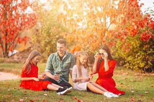 Portrait of happy family of four in autumn day photo