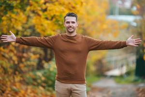 Young man in autumn park outdoors photo