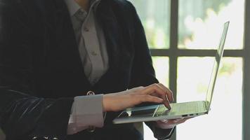 groupe d'hommes d'affaires utilisant une tablette numérique ensemble devant les fenêtres d'un immeuble de bureaux donnant sur la ville video