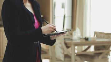 groupe d'hommes d'affaires utilisant une tablette numérique ensemble devant les fenêtres d'un immeuble de bureaux donnant sur la ville video