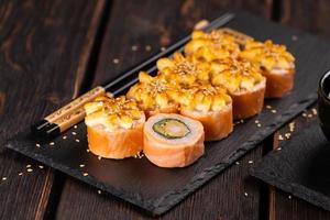 rollo con sushi de pescado con palillos - concepto de comida asiática foto