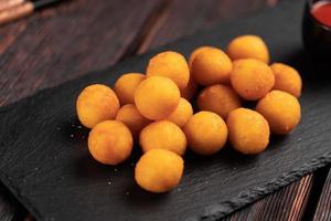 fish balls in batter with chopsticks close-up - asian food top view photo