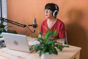 Middle-aged woman radio host making podcast recording for online show - broadcast and dj concept photo