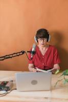 mujer madura haciendo una grabación de podcast para su programa en línea. mujer de negocios atractiva que usa auriculares frente al micrófono para una transmisión de radio foto