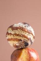 Apple with mold and fresh apple on background - mold growth and food spoilage concept photo