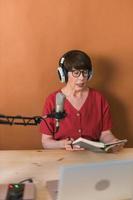 Middle-aged woman radio host making podcast recording for online show - broadcast and dj concept photo