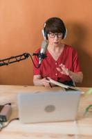 Middle-aged woman radio host making podcast recording for online show - broadcast and dj concept photo