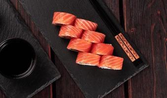 rollo con sushi de pescado y palillos vista superior de primer plano - concepto de comida asiática
