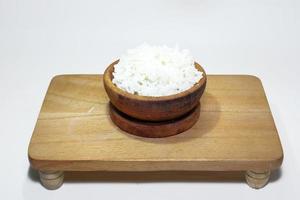 white rice in a wooden bowl on a white background photo