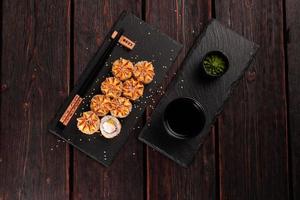 Sushi roll philadelphia with crab avocado and cream cheese on black background top view. Sushi menu. Japanese food concept photo