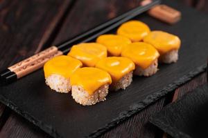 Sushi roll with cheese with chopsticks - asian Japanese food concept photo