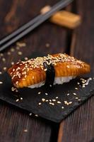 Japanese sushi unagi nigiri sushi smoked eel on wooden background close-up photo