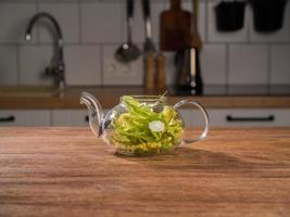 Freshly brewed linden tea in teapot stands on table kitchen background - herbal tea treatment photo