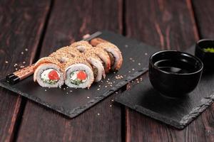 rollo de sushi con anguila ahumada y salmón con pepino y queso. delicioso juego de rollos de sushi fresco tradicional. menú de sushi restaurante de cocina japonesa. comida asiática foto