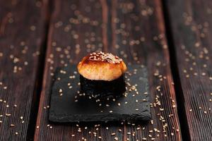 Baked shrimp gunkan on wooden background. Simple gunkan sushi with shrimp tartare with mayonnaise in minimal style. Japanese food - nigiri sushi in nori. Nigiri sushi with fish photo