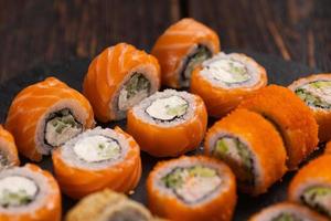 rollos con camarones de pescado y sushi de caviar con palillos - comida asiática y concepto de cocina japonesa foto