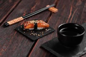 Japanese sushi unagi nigiri sushi smoked eel on wooden background close-up photo