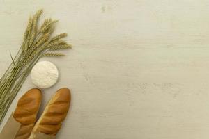 Homemade fresh bread with wheat ear on white wood table. photo