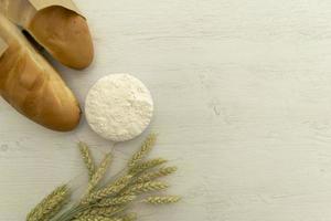 Homemade fresh bread with wheat ear on white wood table. photo