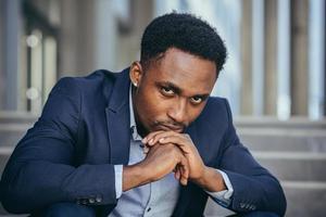 Depressed african american businessman looking at camera close up portrait photo