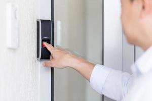 Close-up photo. The hand of a man in calls the intercom of the house, presses the button photo