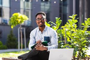 el estudiante estudia en línea de forma remota, el hombre afroamericano sonríe y se regocija foto