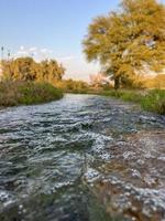 flujo de agua de riego desde la tubería hasta el canal para campos agrícolas foto