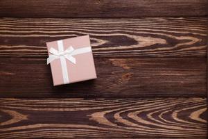 Present box on wooden background, copy space photo