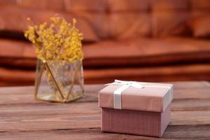 Present box on wooden table in living room photo