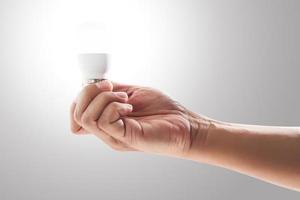 Light bulb on human hand with gray background. photo
