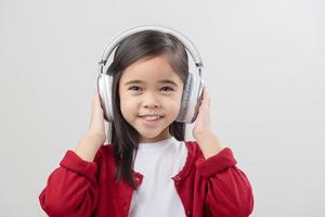 Lttle girl Asia cute enjoying her music headphones photo